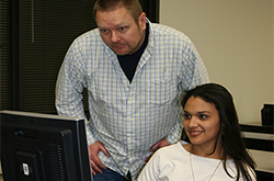 BAS program instructor assisting student at computer