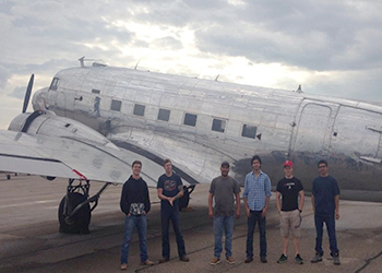 MC students standing in front of a vintage plane