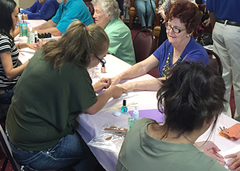 Cosmetology students givinging manicures to senior citizens