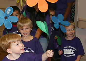 Children holding and looking at big flowers