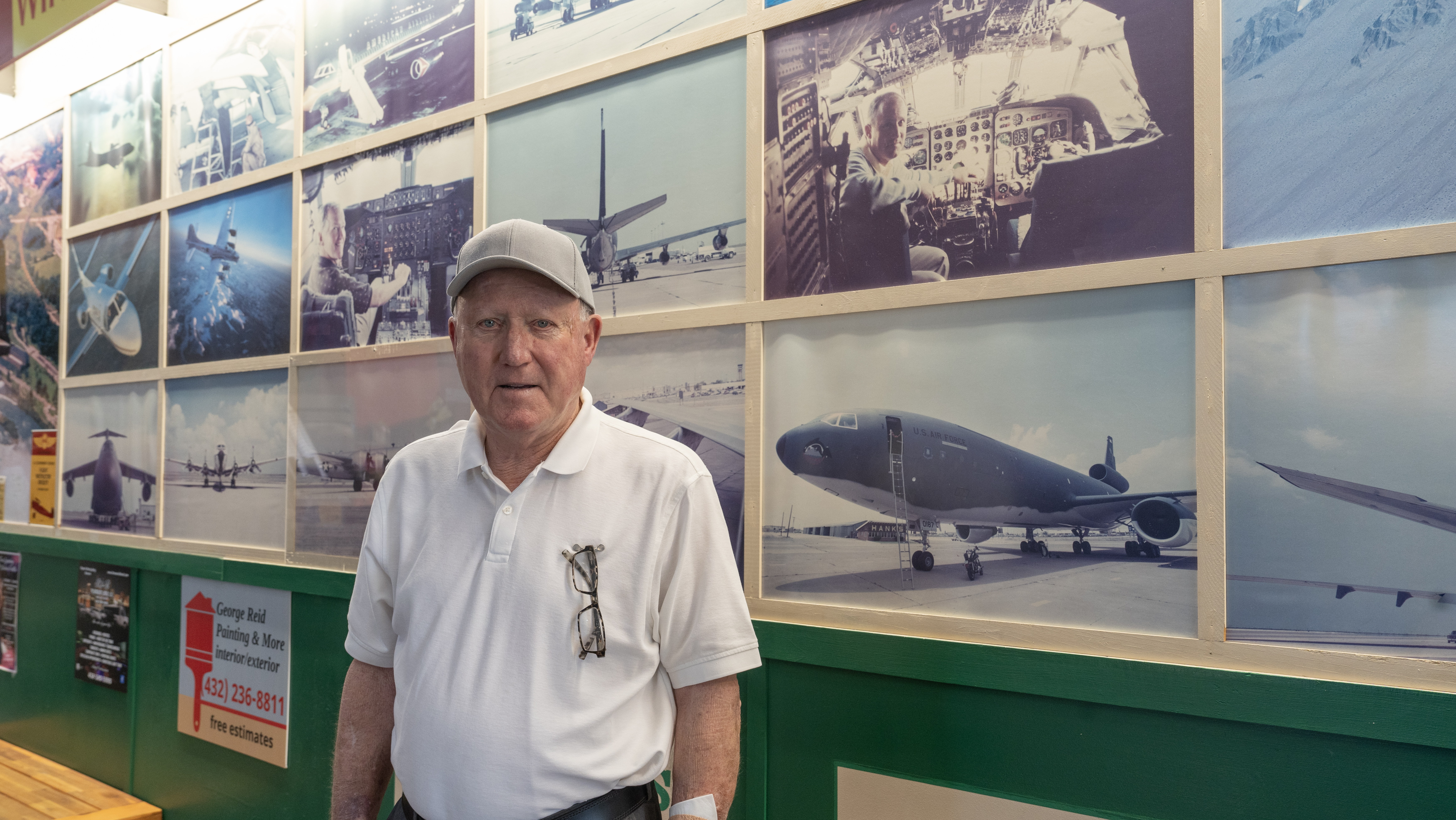 sMichael's Charcoal Grill owner, Michael Shapira, poses in front of a wall of airplane photographs that lines his restaurant.