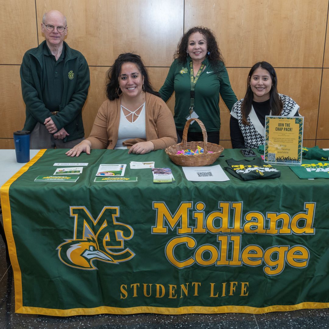 smc's student life team waits at an MC-decorated table to greet families with information about MC resources