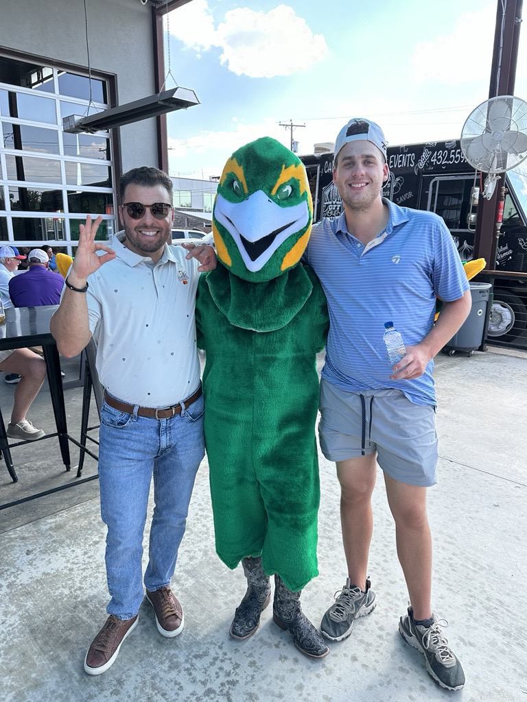 The image to use for this article. Listing image managed through RSS tab. Pepe the mascot posing with two alumni members at Tall City Invitational