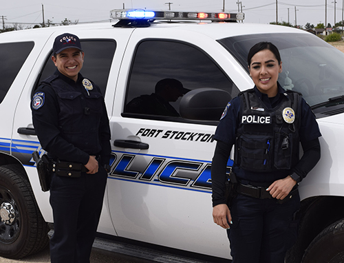 Two Police officers standing in front of a Fort Stockton police SUV